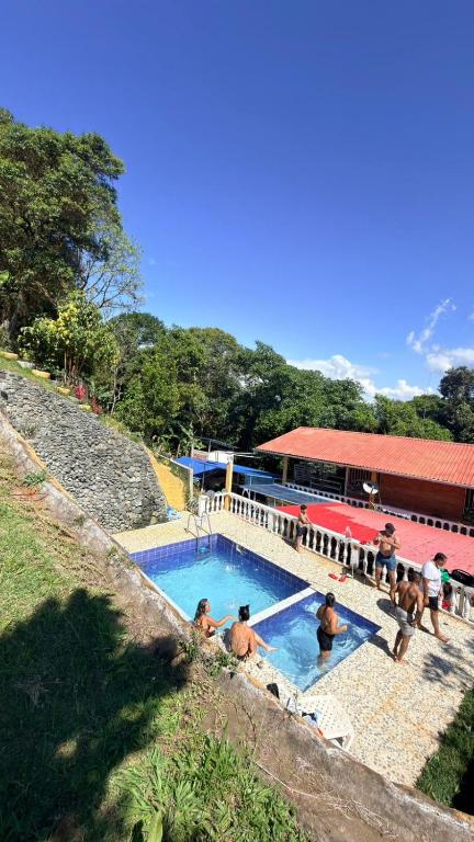 a group of people sitting around a swimming pool at Casa Lucy in Yumbo