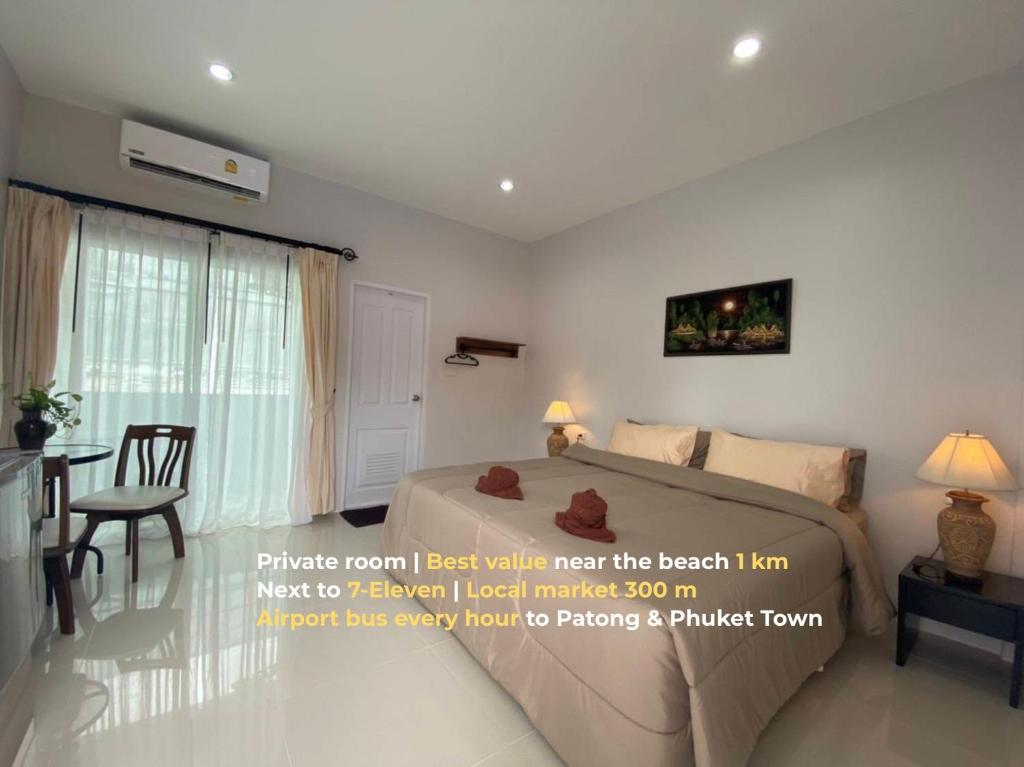 a bedroom with a bed and a living room with a table at MONDEE House @The Airport in Thalang