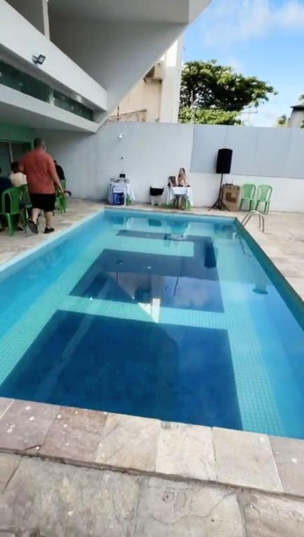 a large blue swimming pool with a person standing next to it at CASAMAR Olinda in Olinda