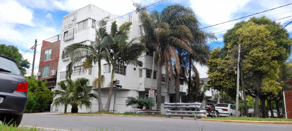 a white building with palm trees in front of it at Palmeras II in Vicente López