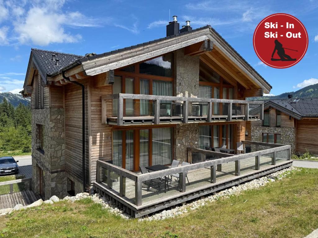 a log house with a large deck in front of it at Apartman Brhliska in Belá