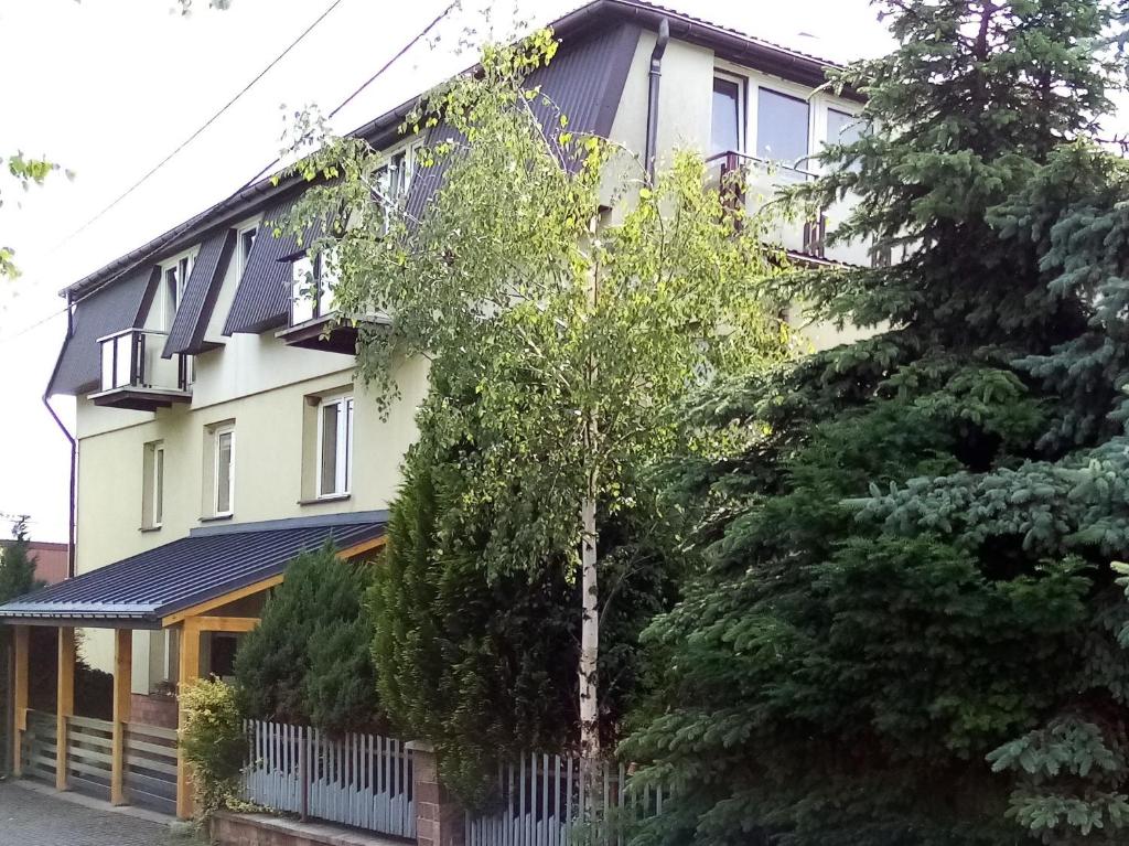 a house with trees in front of it at Noclegi Spoko in Mąchocice