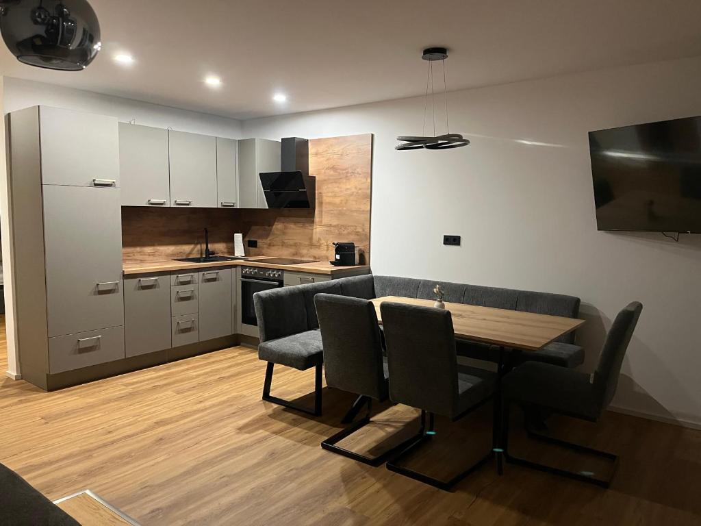 a kitchen with a table and chairs in a room at Moderne Ferienwohnung nahe Salzburg & Eugendorf in Eugendorf