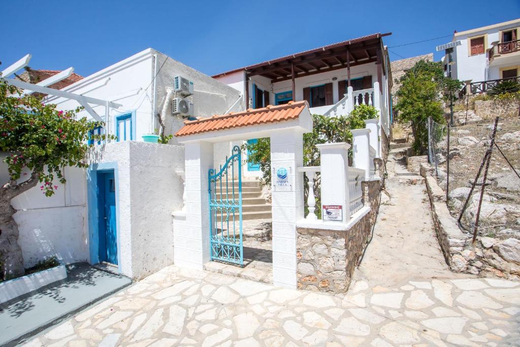 a house with a blue door on a street at Isminis Villa in Halki