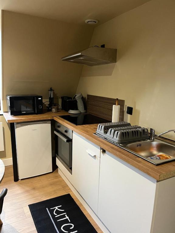 a small kitchen with a sink and a counter top at Appartement de Charmes dans le Centre de Cherre in Cherré