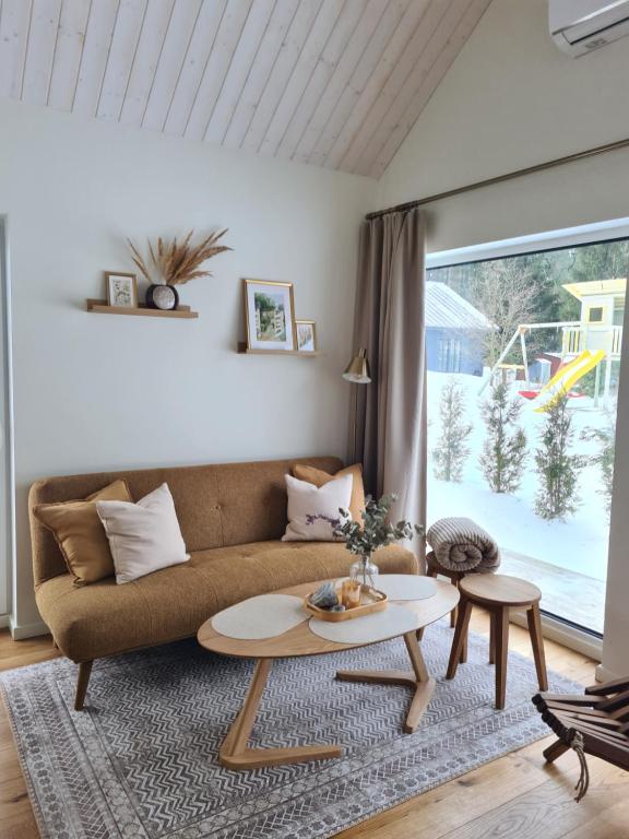 a living room with a couch and a table at Salmistu Saunamaja in Salmistu
