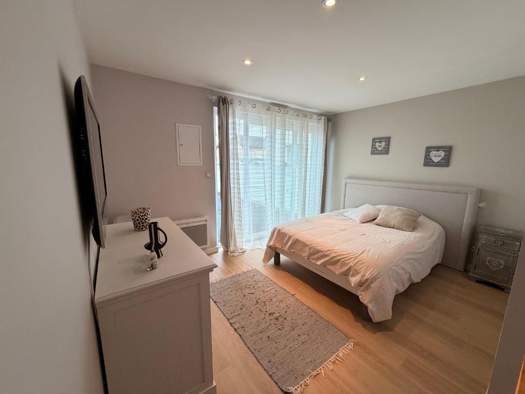 a bedroom with a bed and a large window at La Perla in Mont-de-Marsan