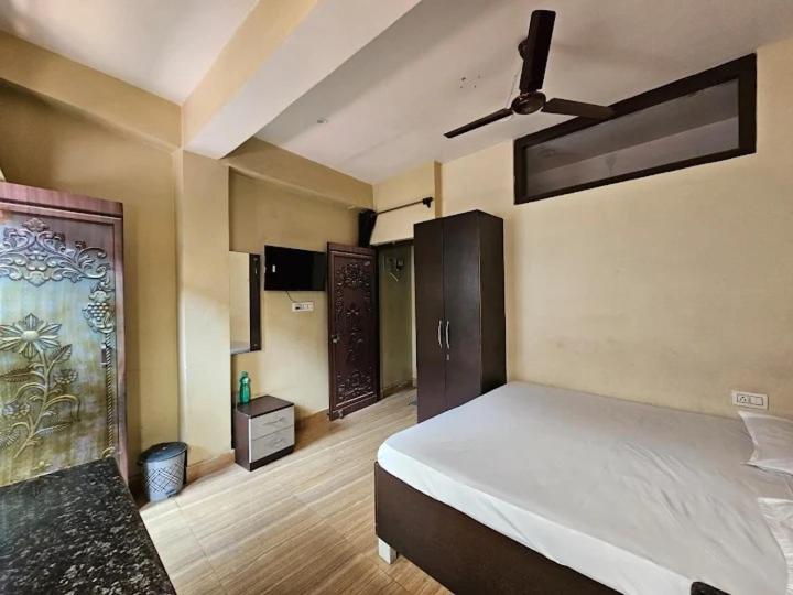a bedroom with a bed and a ceiling fan at Krishna Homestay in Bhowāli