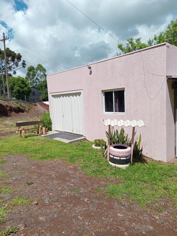 a small pink building with a barrel in front of it at Casa Rosa in Frederico Westphalen