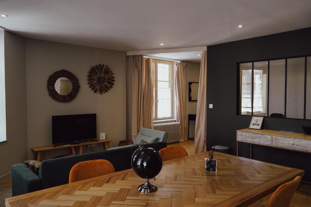 a living room with a couch and a table at Les Suites Gueguen in Chablis