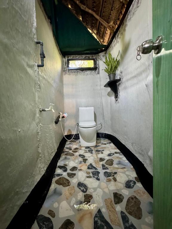 a bathroom with a toilet in a room at Lakeview Birdsong Cabanas in Debarawewa