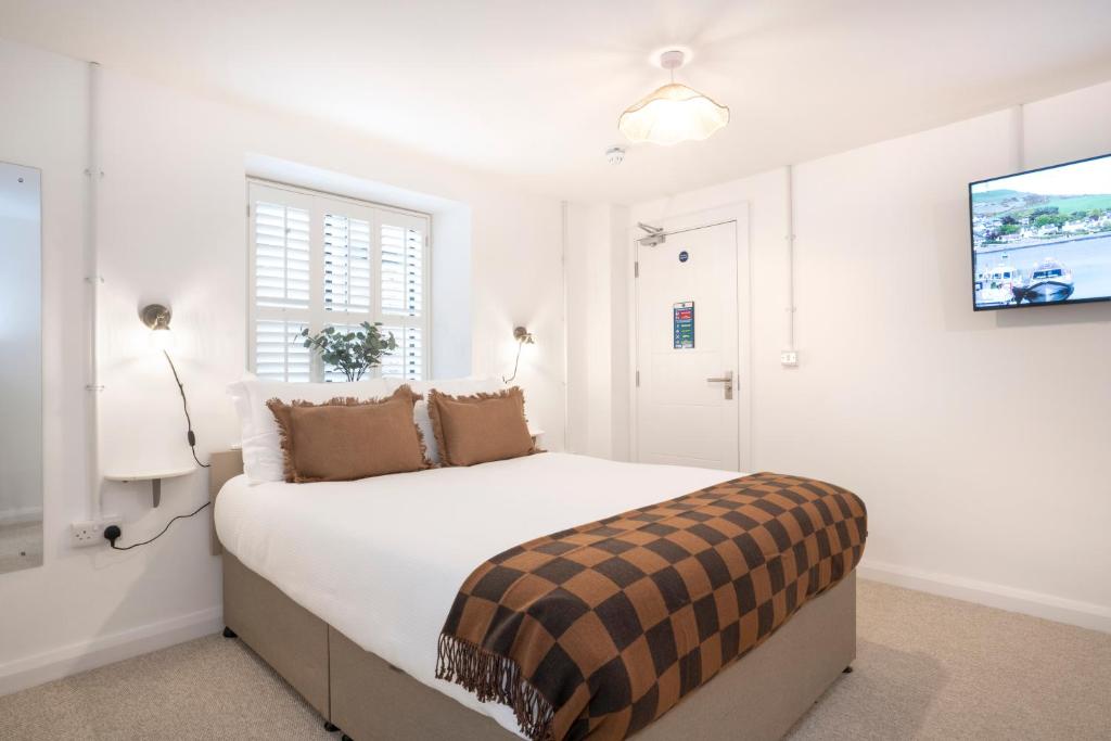 a white bedroom with a large bed and a tv at Apartment ONE in Sherborne