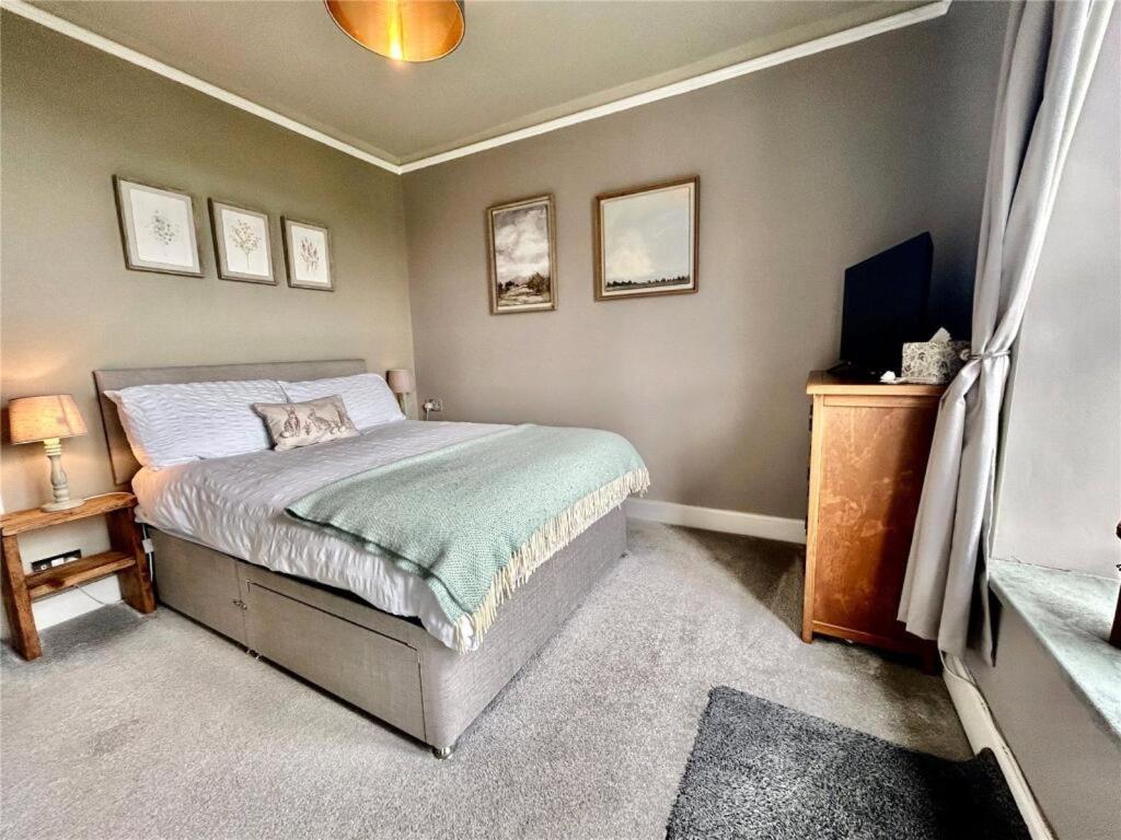 a bedroom with a bed and a television in it at Island View in Benllech