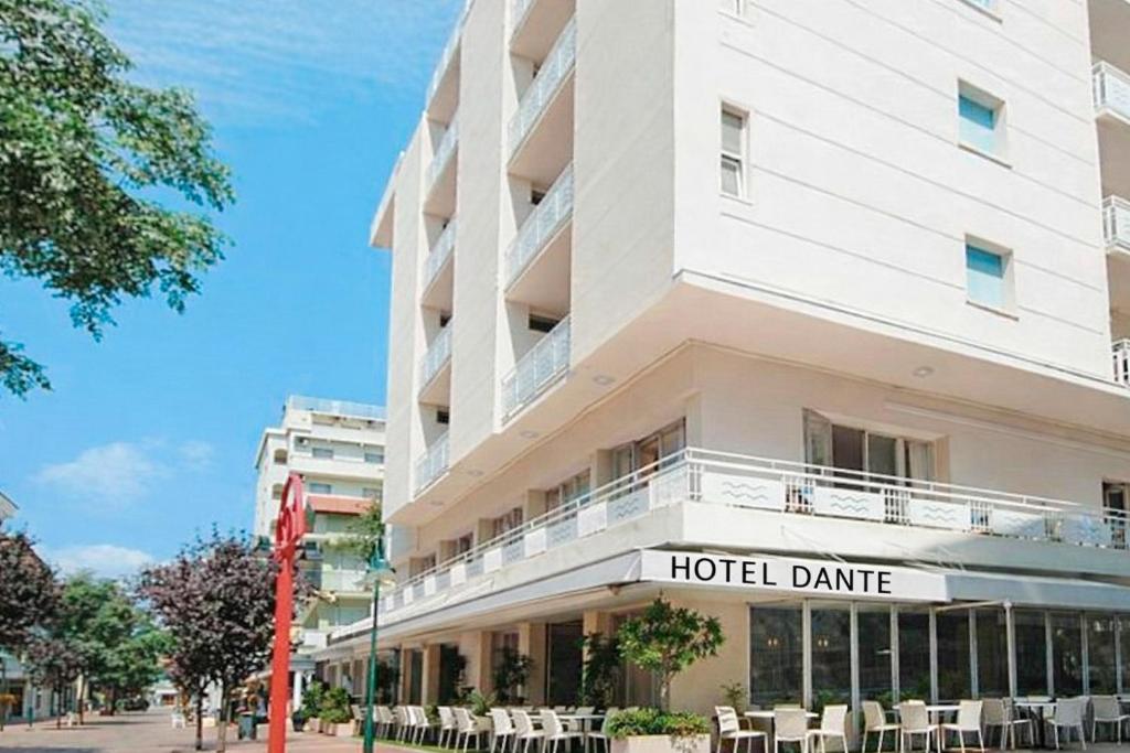 a hotel dmg with tables and chairs outside of it at Hotel Dante in Cattolica