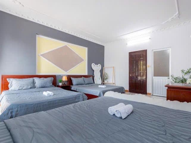 a bedroom with two beds with towels on them at The Warm khách sạn bãi sau giá rẻ in Vung Tau