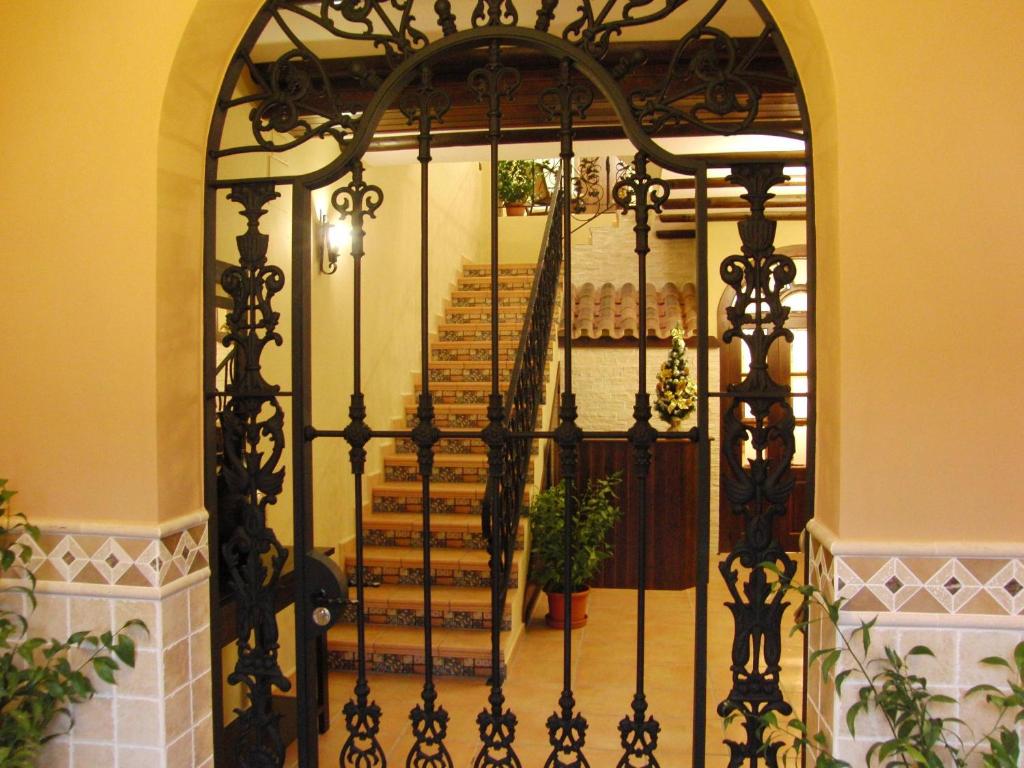 an iron gate in a hallway with a staircase at Hotel El Romeral in Almadén de la Plata