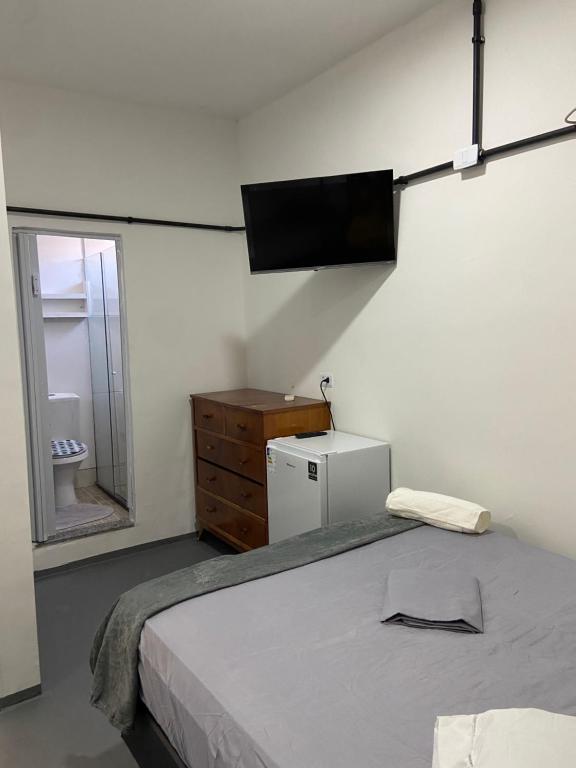 a bedroom with a bed and a television on the wall at Pousada Valverde Suíte 2 in Rio de Janeiro