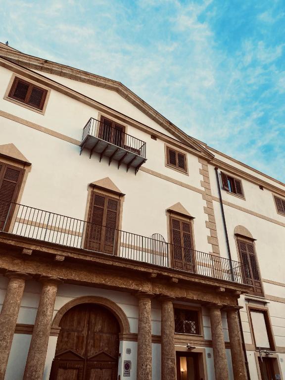 a white building with a balcony on top of it at Dimora Beatrice in Termini Imerese