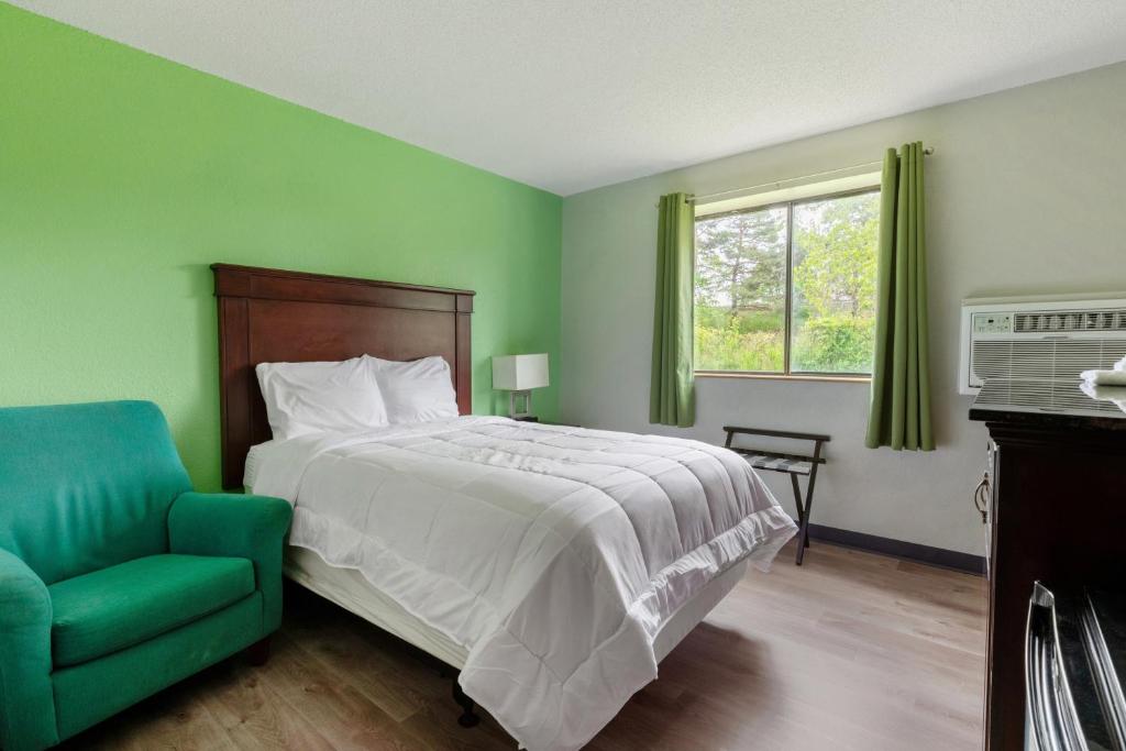 a green bedroom with a bed and a green chair at Studio in Lansing in Lansing