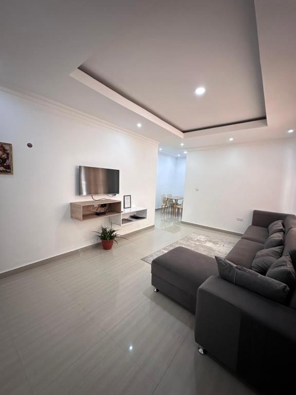 a living room with a couch and a tv at Blue leaf apartments in Lusaka