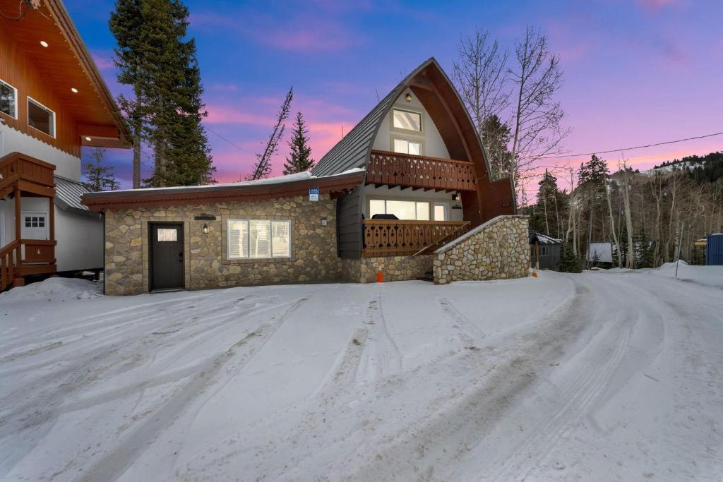 a house with a snow covered driveway in front of it at Chalet at Brighton in Brighton