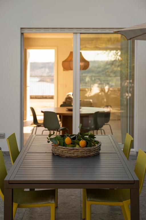 a dining room table with a basket of oranges on it at CasaCeciliamare in Ortona
