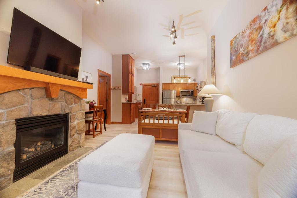 a living room with a white couch and a fireplace at Aspen Glen in Solitude