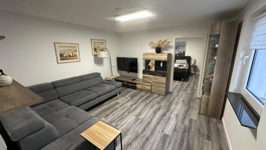 a living room with a couch and a television at KüstenNest gepflegte großzügige Ferienwohnung Nähe Ostsee mit Garten in Ratekau
