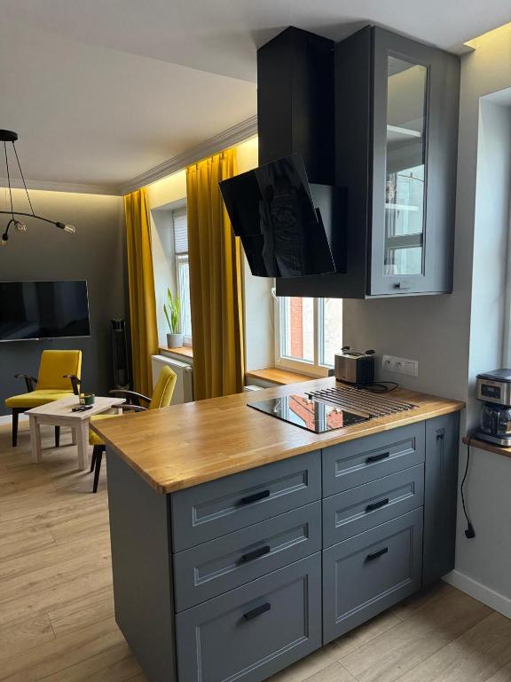 a kitchen with a counter top and a living room at Apartament u Laury in Mrągowo