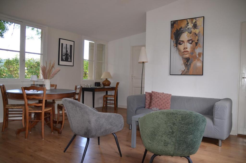 a living room with a couch and a table and chairs at Chateau de Salorges - Field gite I in Corancy