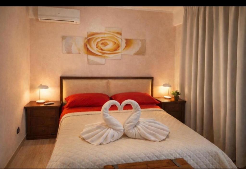 two white swans sitting on a bed in a bedroom at VILLA DEI CICAS in Taranto
