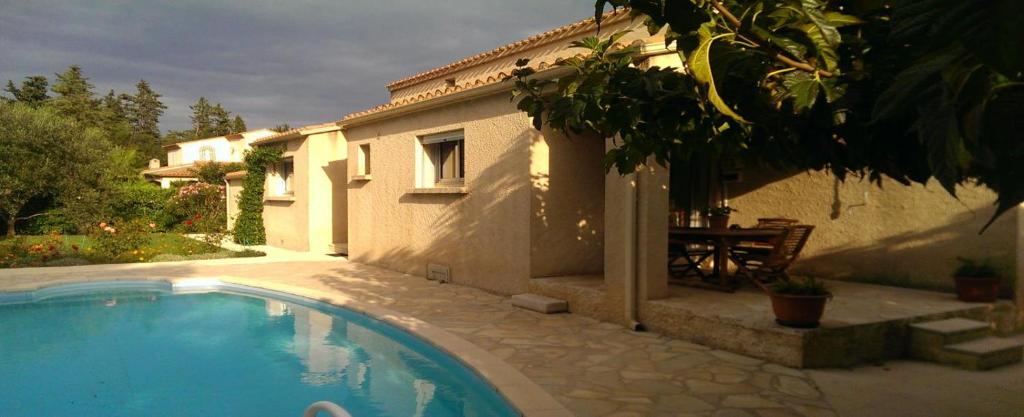 a house with a swimming pool in front of a house at Chambre d'hôtes à Juvignac in Juvignac