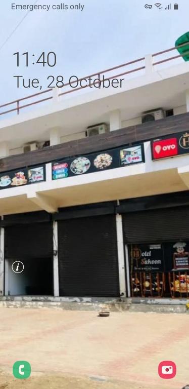 a building with two garage doors with clocks on it at sukoon hotel in Jīnd