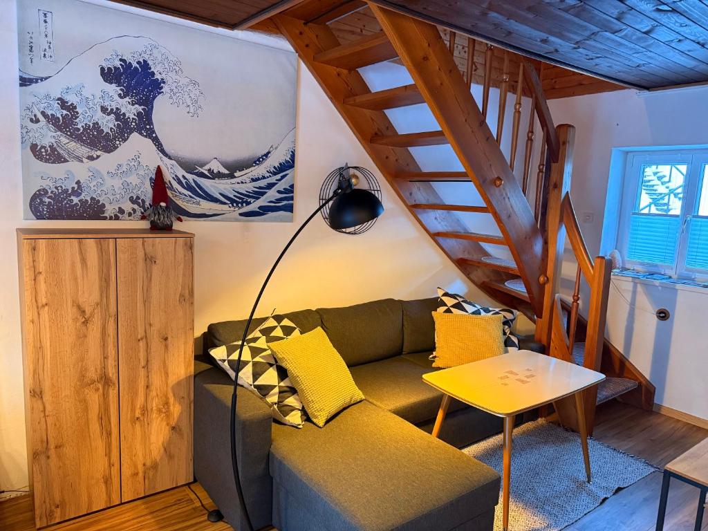 a living room with a green couch and a staircase at White Rabbit Apartment in Spital am Semmering