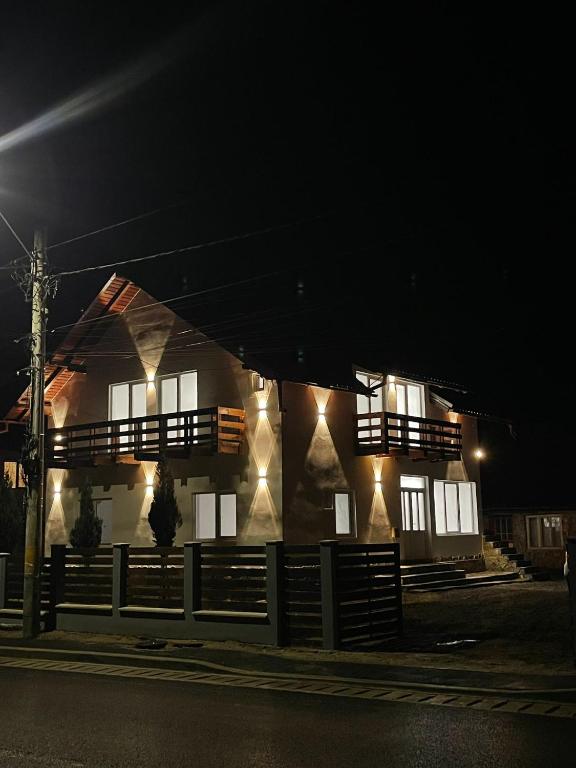 ein Haus mit Lichtern an der Seite bei Nacht in der Unterkunft Silent Hills in Moieciu de Jos