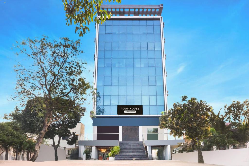 a tall glass building with a sign on it at Super Townhouse Lohegaon Near Pune Airport Formerly Landmark Regency in Pune