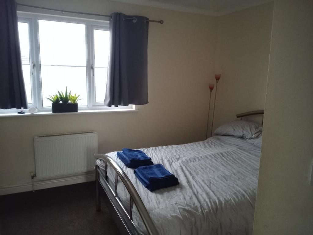 a bedroom with a bed with two blue towels on it at Noglas in Ammanford