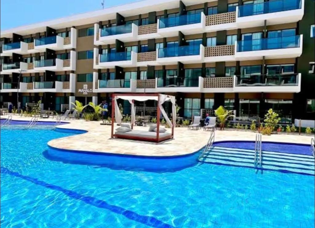 a hotel with a swimming pool and a building at Mana Beach Experience in Ipojuca