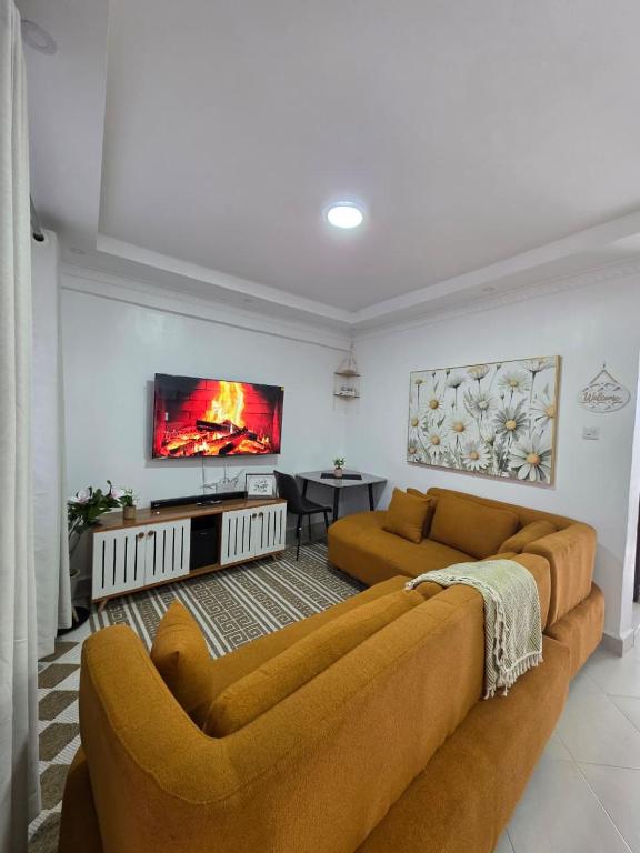 a living room with a couch and a tv at Jay Homes -Ultra Modern Naivegas Apartments in Naivasha