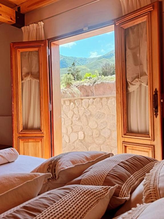 a bedroom with a window with a view of a mountain at CasaVid - Private Boutique Chalet & Spa - Vistas 360 in Tafí del Valle