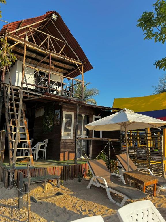 a house with chairs and an umbrella in front of it at La playita ocean view in Playa Blanca