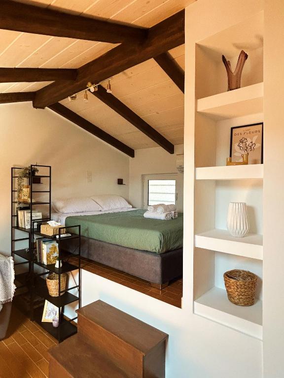a bedroom with a green bed and shelves at Hestia loft in Nafplio
