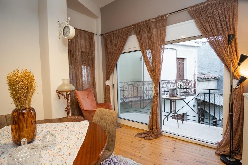 a living room with a table and a large window at Mary's cozy apartment 2 in Pýrgos