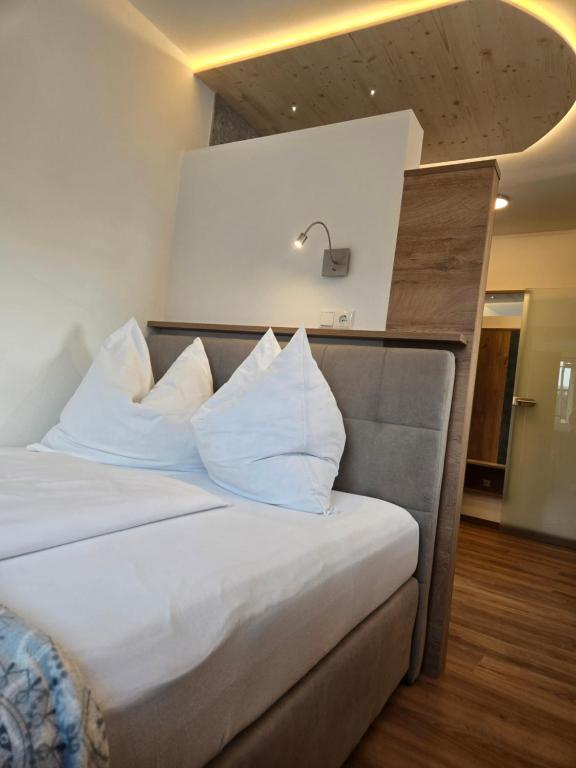 a bedroom with a bed with white sheets and pillows at Landhof Harrauer in Erlauf