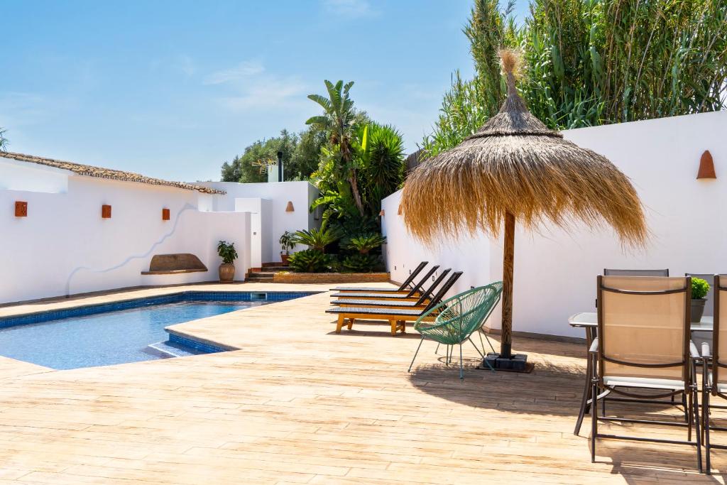 a patio with chairs and an umbrella and a swimming pool at Casa de campo Canoret, Benissa, Alicante , Spain in Benissa