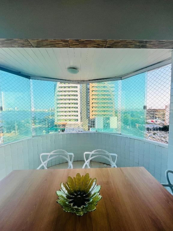 a table with a flower on it in a room with windows at Ocean Tower in São Luís