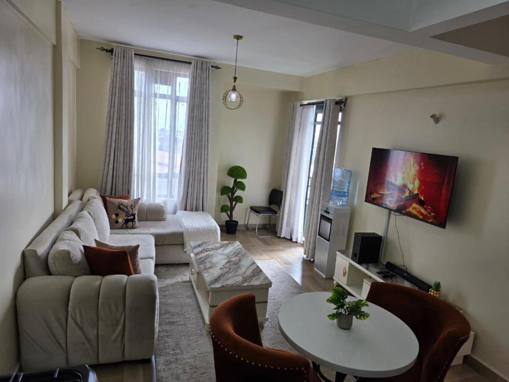 a living room with a couch and a table at Jay Homes - Modern & Cozy Apartments PGS Plaza - Nakuru CBD in Nakuru