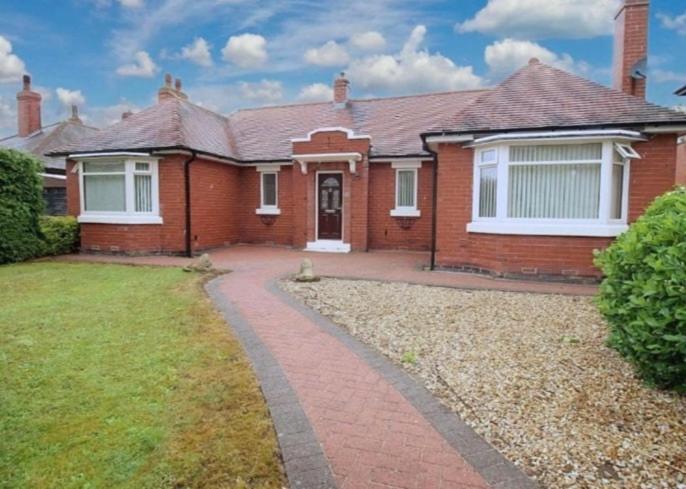 a red brick house with a brick driveway at Spacious Dinnington bungalow in Dinnington