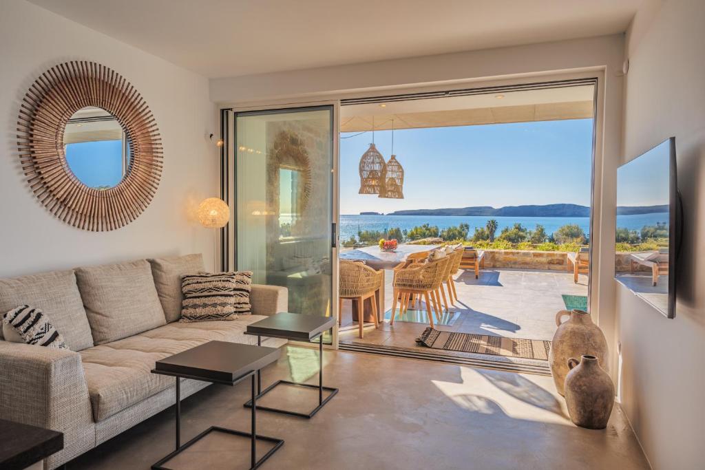 a living room with a couch and a large glass door at Penthouse Villa with Private Pool, Sauna & Seaview in Gialova