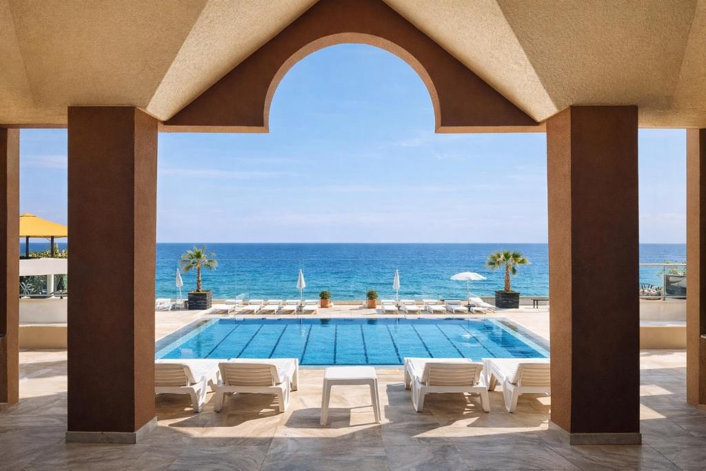 a view of a swimming pool and the ocean at Gondola Marine Resort in Ḩālāt